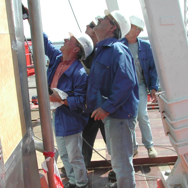 Travailleurs en inspection sur une plateforme industrielle, portant des équipements de protection individuelle, assurant la sécurité des installations. Control Safe Energy.